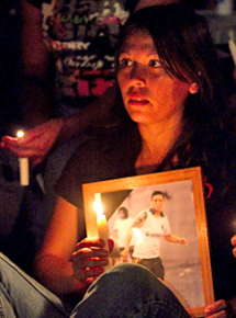 A mourner holds a photograph of Norma Hurtado during a vigil for Norma and her mother