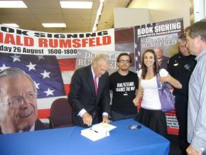 Jorge Gonzalez and Ashley Joppa-Hagemann with Donald Rumsfled (left) as he prepares to sign a copy of his book